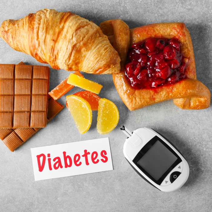 digital glucometer card with word diabetes sweets table
